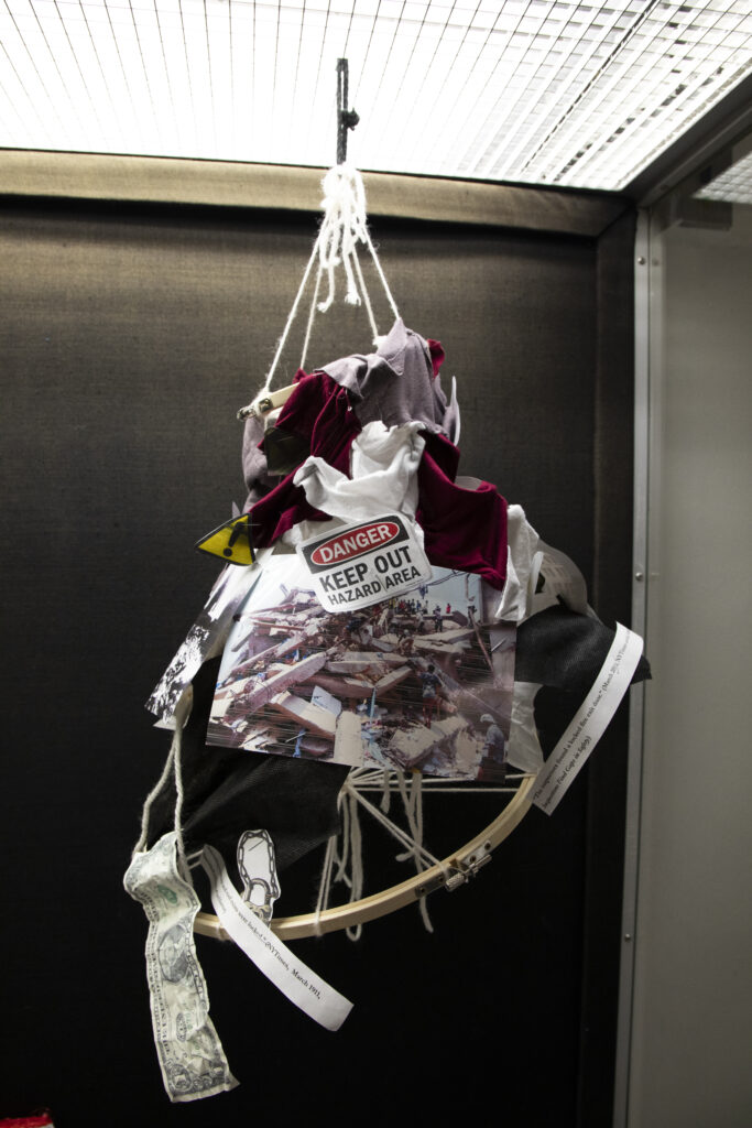 tiered mobile containing text, photographs, and textiles to convey the overarching theme of— issues plaguing labor conditions